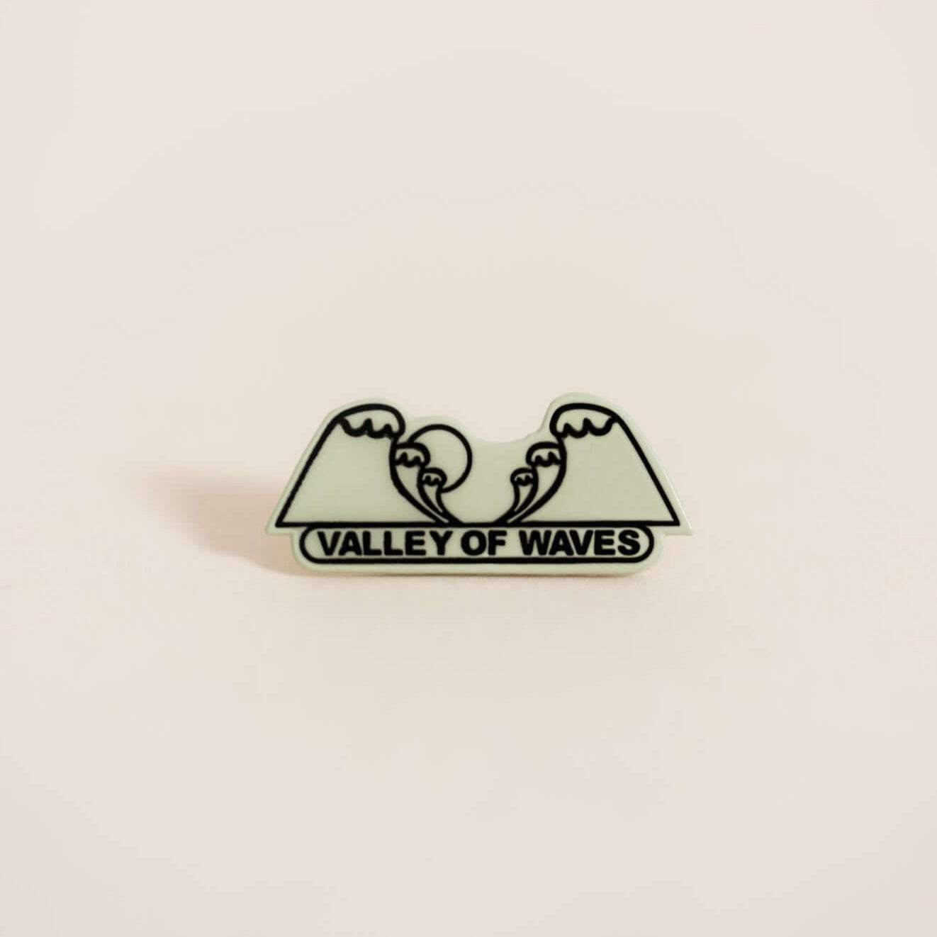 Stylish metal pin displaying waves. Embossed with epoxy resin coating.