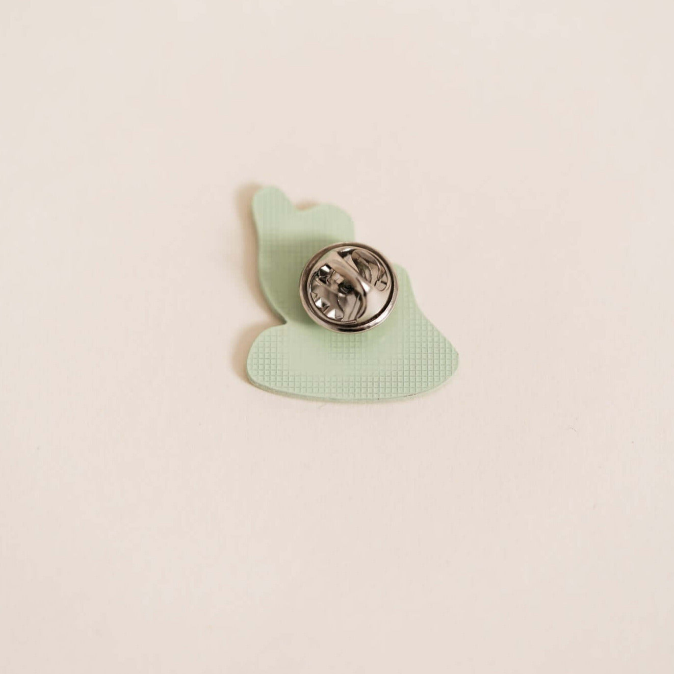 Back of stylish metal pin displaying waves. Embossed with epoxy resin coating.